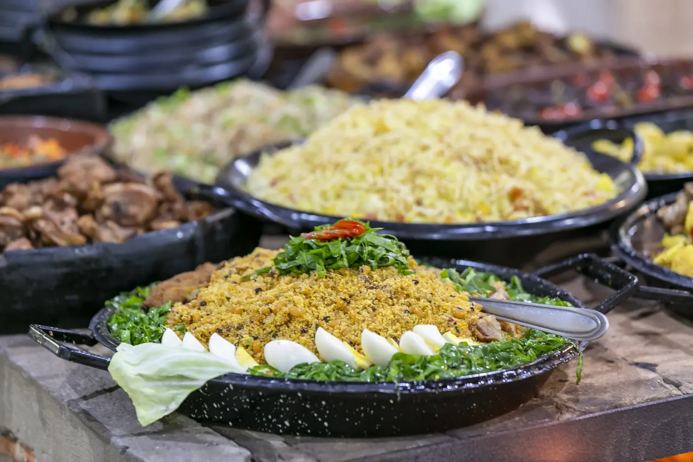 Buffet em panelas de barro e ferro no fogão a lenha