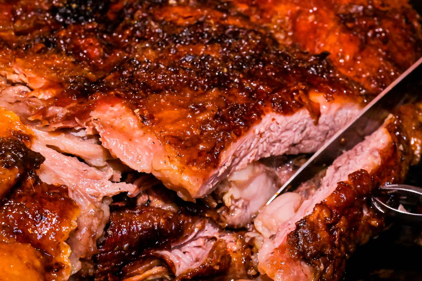 Carne assada sendo fatiada com faca