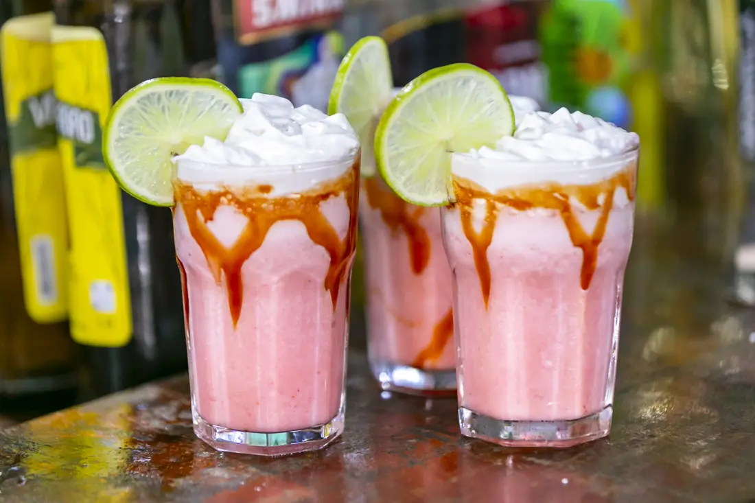 Três drinks cremosos de morango com calda e limão