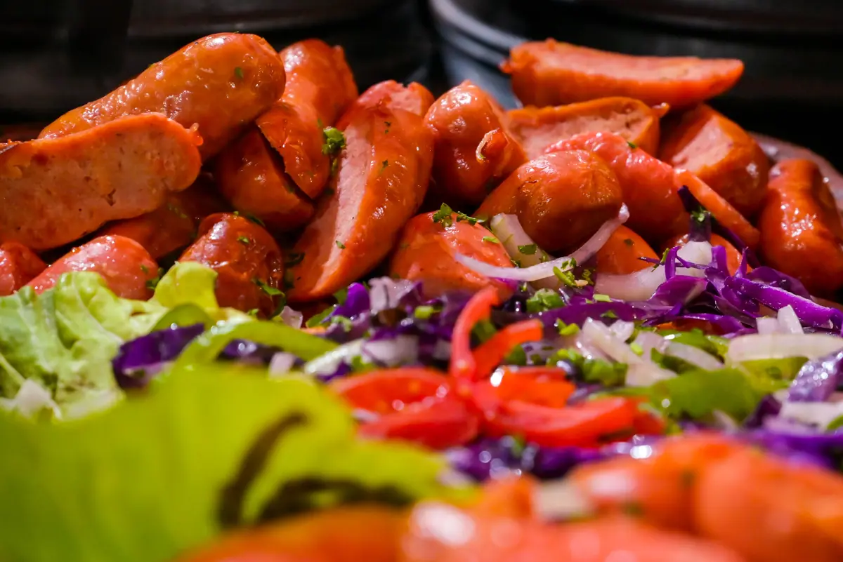 Linguiça assada sobre salada colorida
