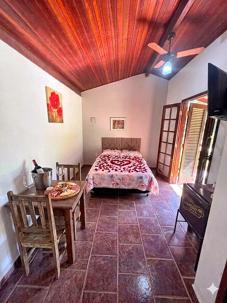 Suíte com mesa, cadeiras e ventilador de teto