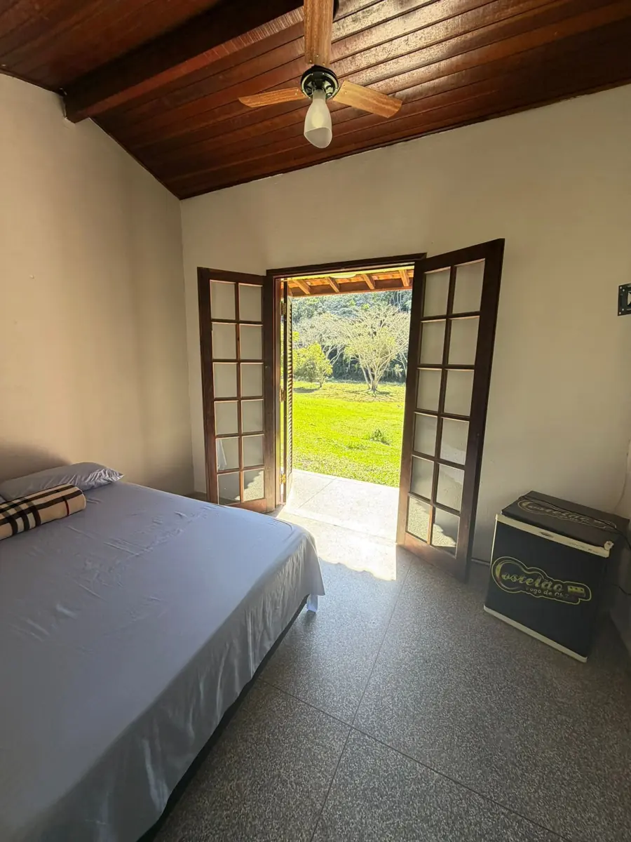 Cama de casal ao lado da porta para o jardim